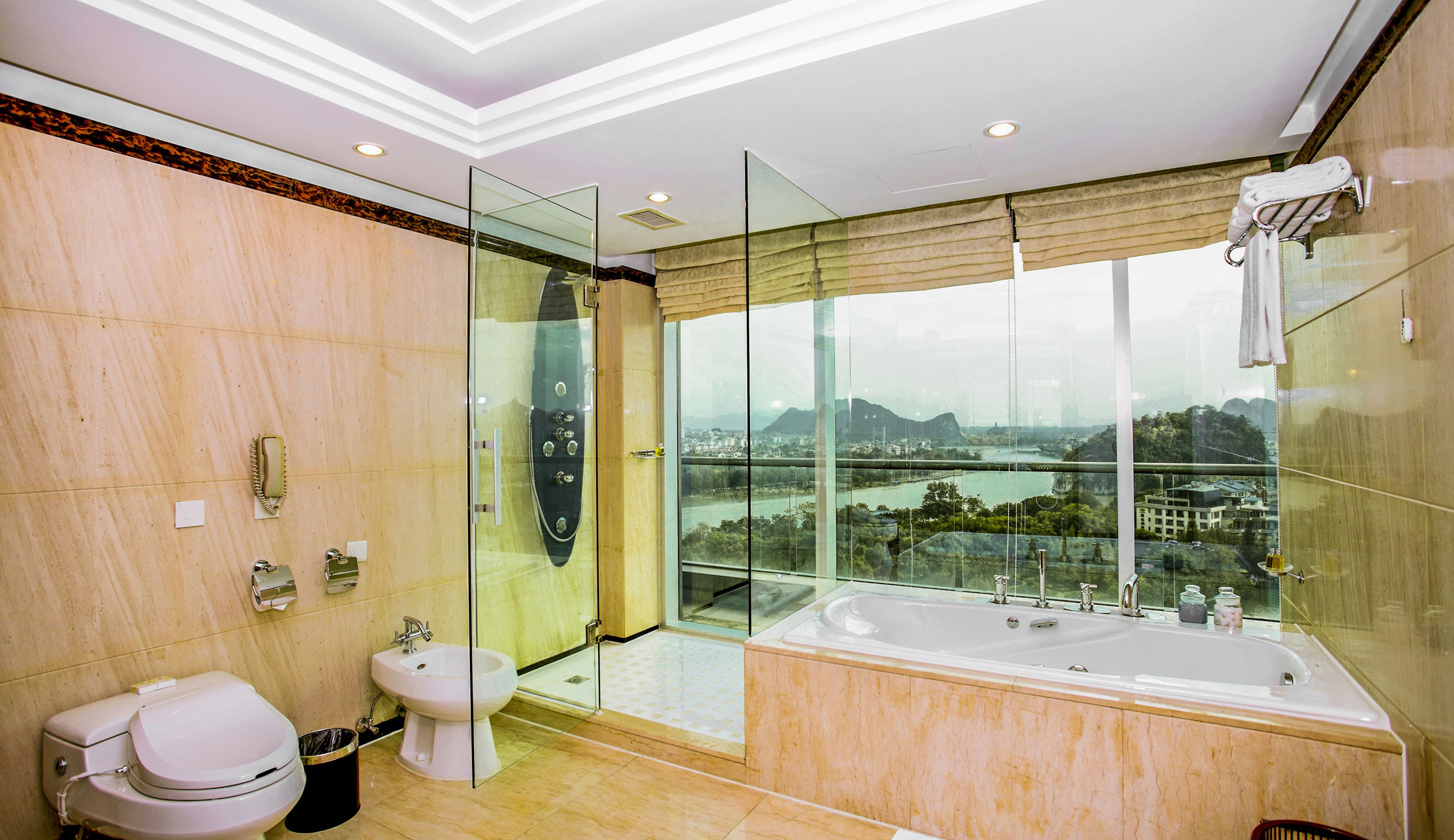 Un baño moderno con cabina de ducha de vidrio, una bañera grande y un inodoro.