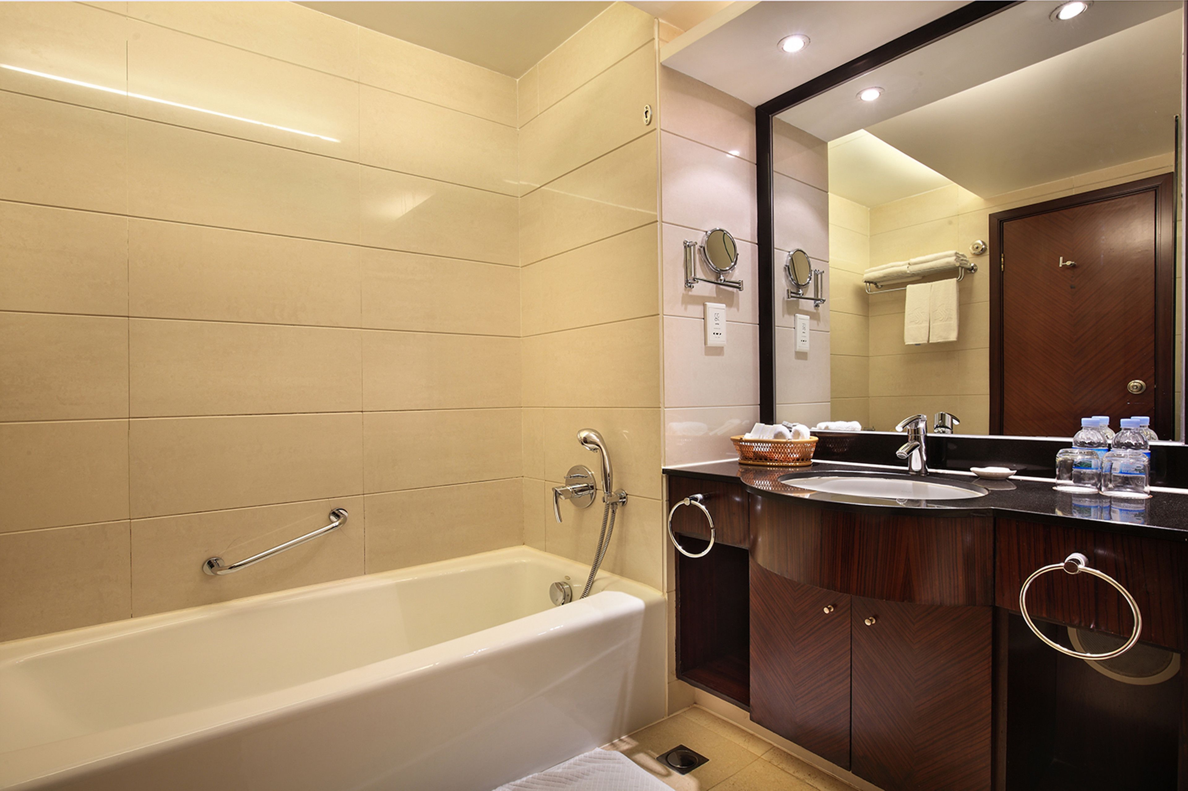 A modern bathroom with a bathtub, a sink, and a mirror.