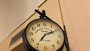 A clock with the text "Grand Central Terminal New York" hanging from a chain.