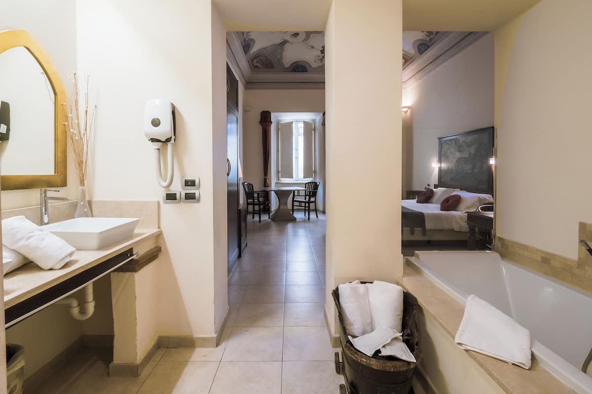 Un baño de hotel con lavabo, espejo y bañera.