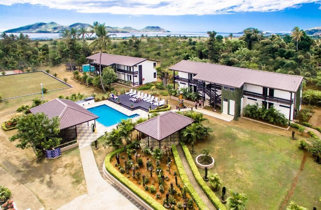 A resort with multiple buildings, a swimming pool, and a well-maintained garden.