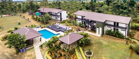 A resort with multiple buildings, a swimming pool, and a well-maintained garden.