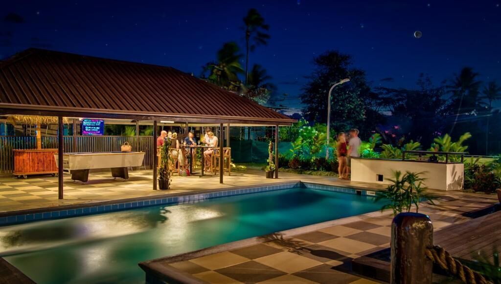 Un espace aménagé au bord de la piscine, avec un coin salon abrité et un bar.
