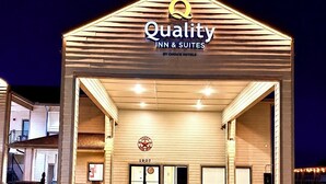 A hotel entrance with a sign reading 'Quality Inn & Suites by Choice Hotels.'