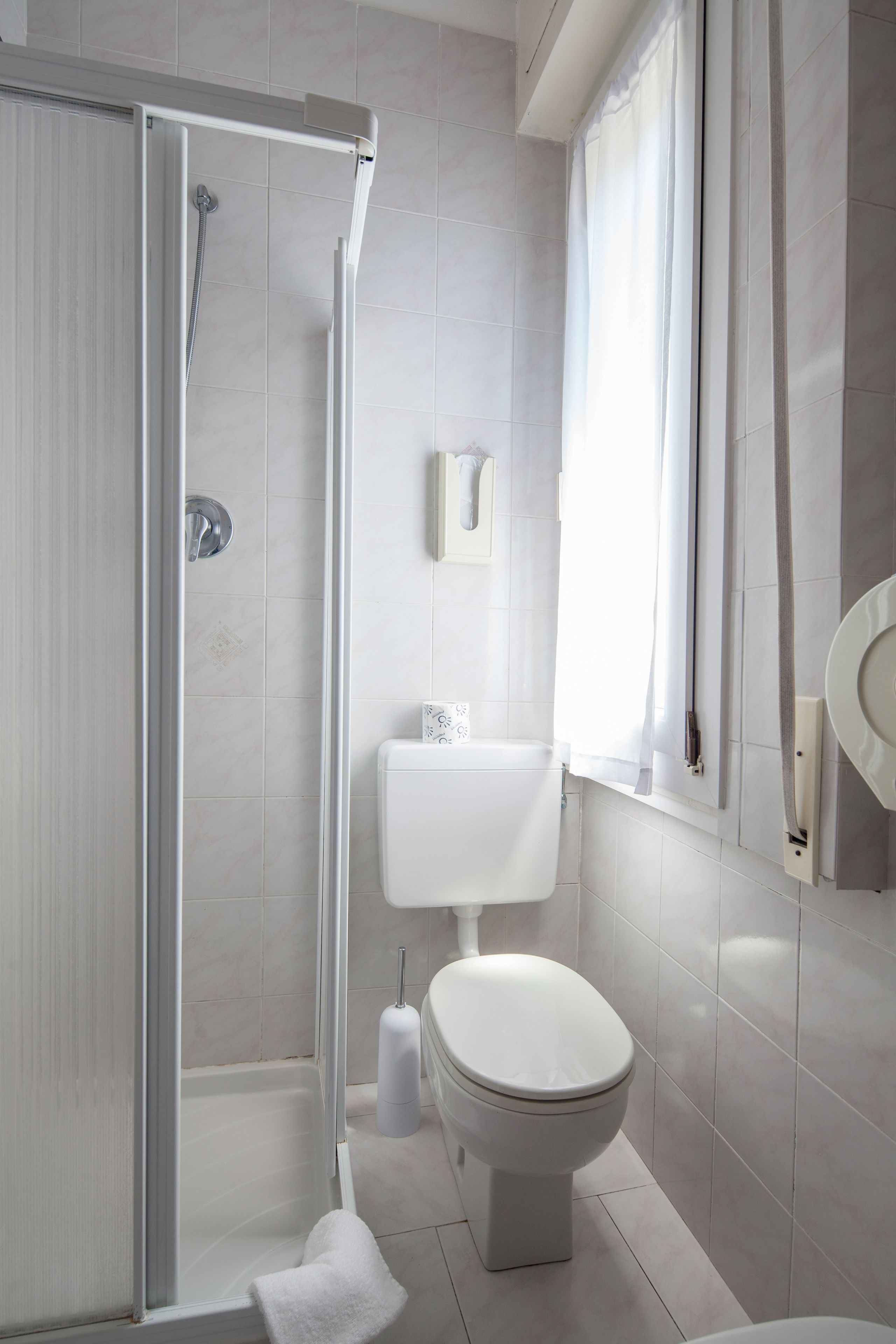 Un bagno moderno con box doccia in vetro, un water e un lavandino.
