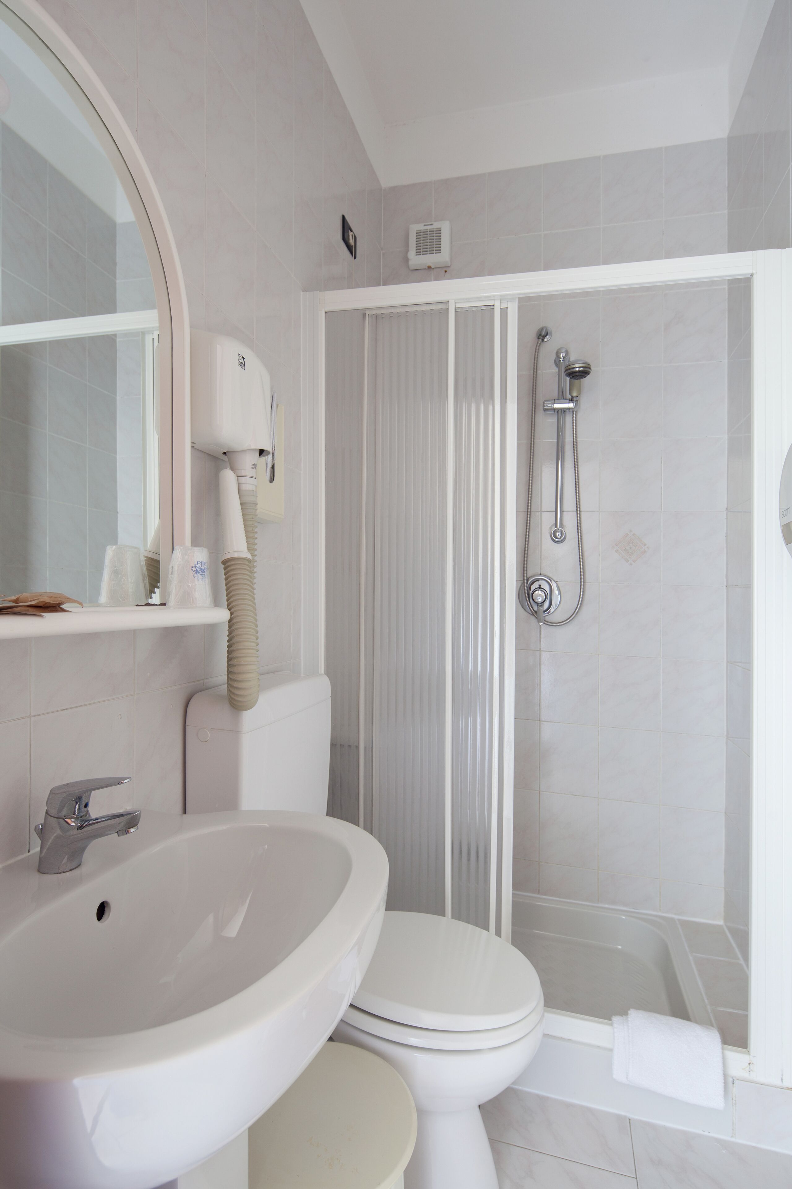 Un baño con lavamanos, inodoro y ducha.