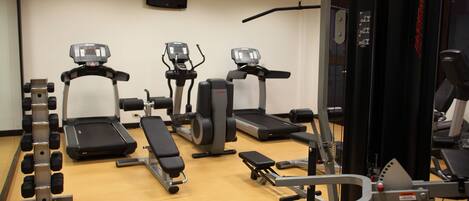 A gym with treadmills, elliptical machines, and weightlifting equipment.