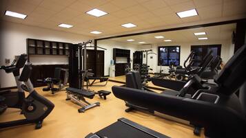 A gym with various exercise equipment, including treadmills, stationary bikes, and weight machines.