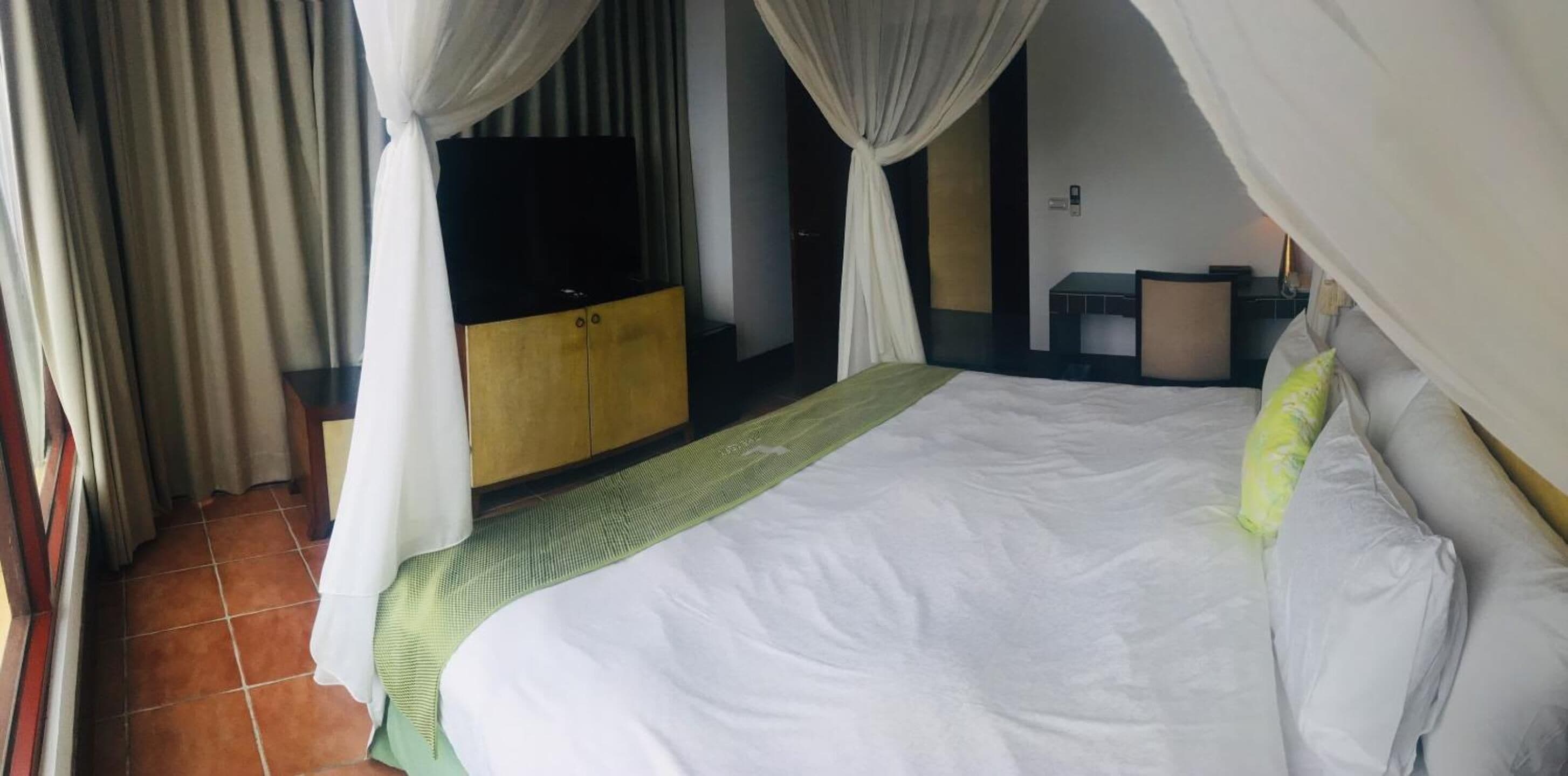 Ein Hotelzimmer mit einem Bett, einem Schrank, einem Schreibtisch und einem Stuhl.