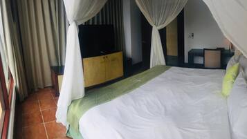 Una habitación de hotel con una cama, un armario, un escritorio y una silla.