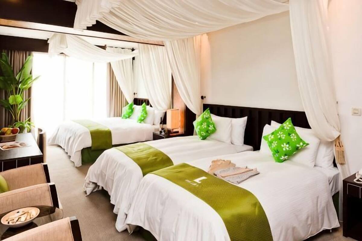 A hotel room with two beds, a desk, and a chair.