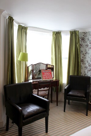A room with two leather chairs, a table with a mirror, and a lamp. - Hudsons (Brighton)