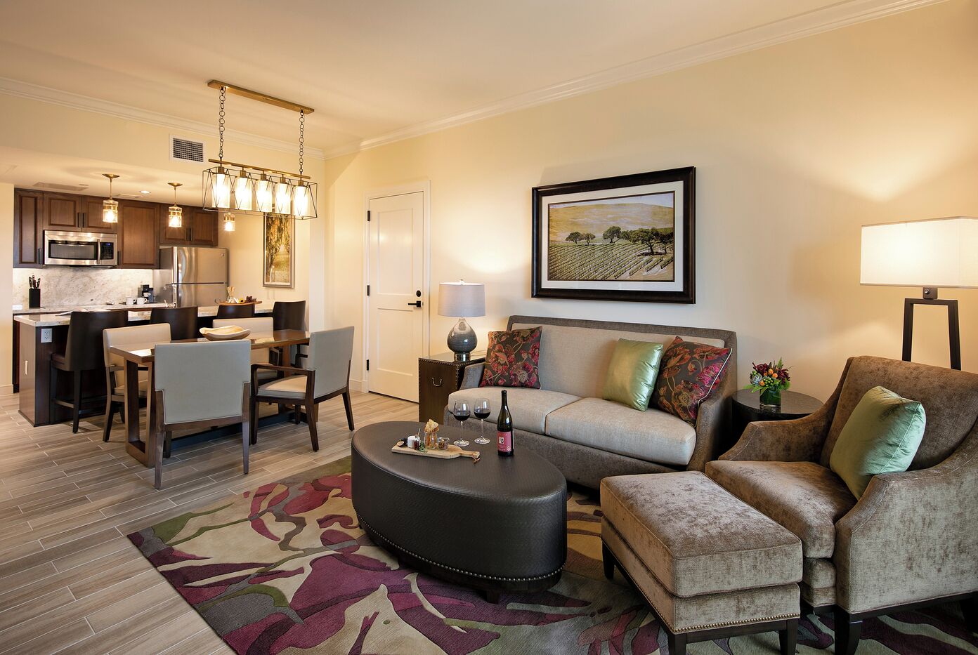 A modern living room with a sofa, ottoman, and dining area.