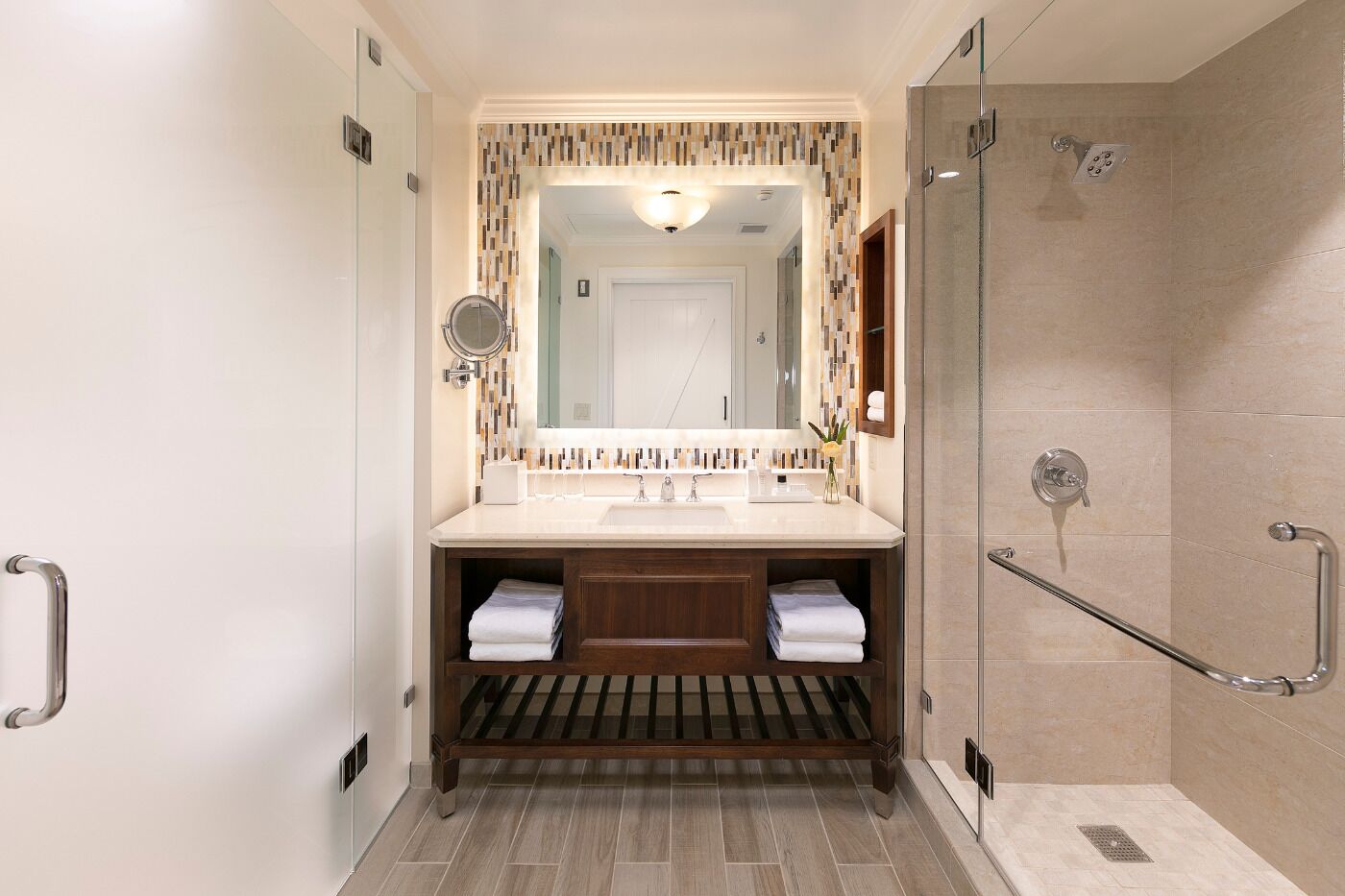 A modern bathroom with a shower, a sink with a mirror, and a towel rack.