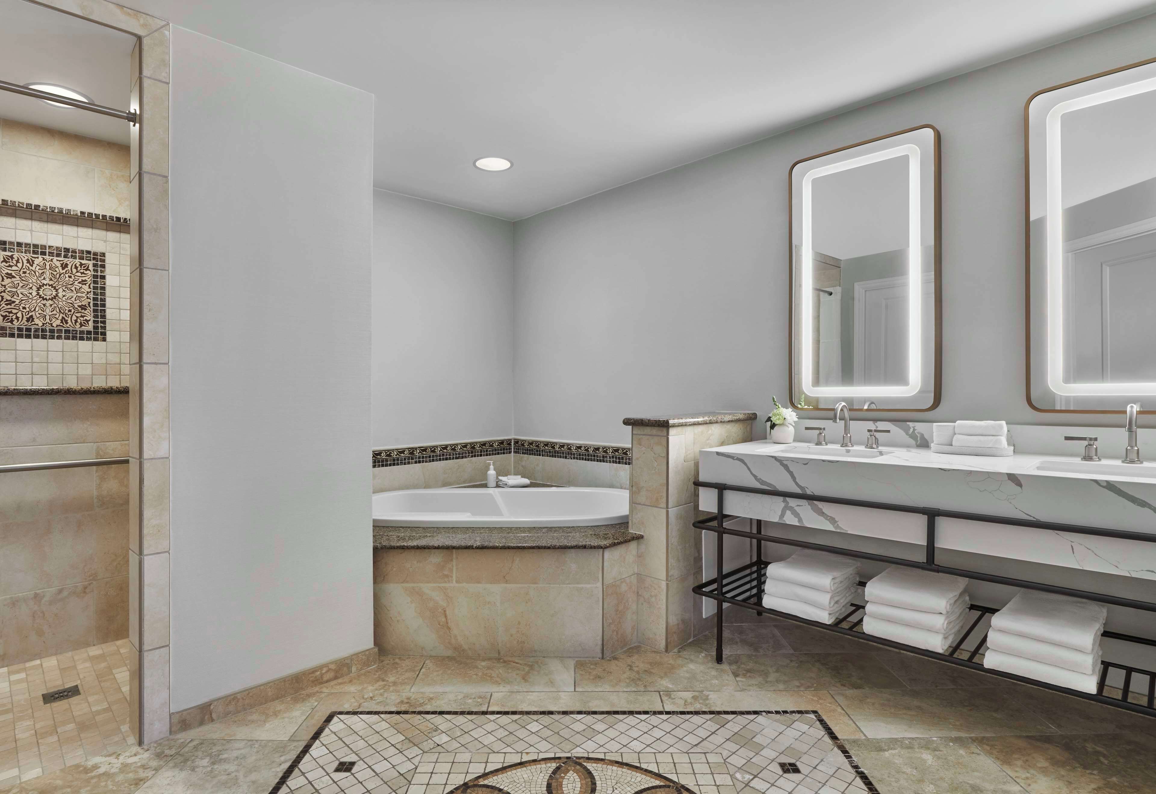 A modern bathroom with a large sink, a bathtub, and a shower area.