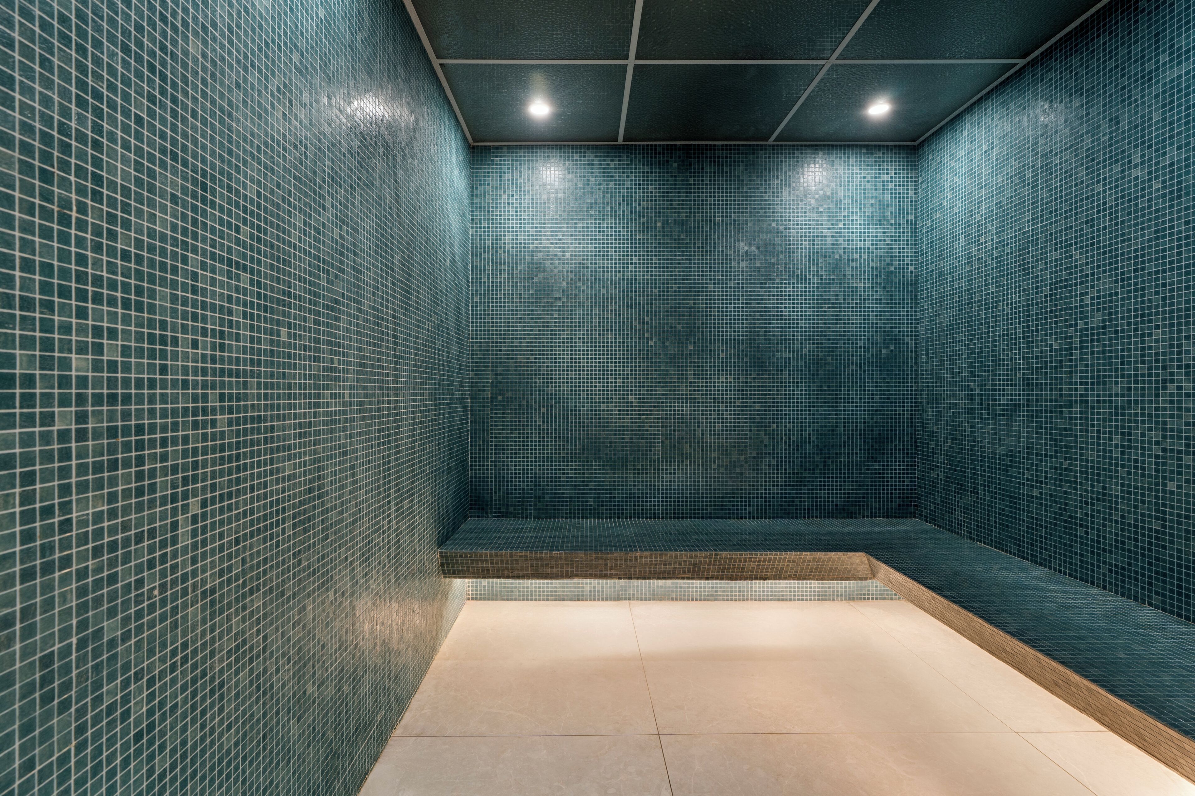Une salle de bain carrelée avec un espace douche d’angle.