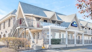 A Days Inn with a stone facade, a covered entrance, and a staircase leading to the upper level. - Days Inn by Wyndham Springfield/Phil.Intl Airport (Springfield)