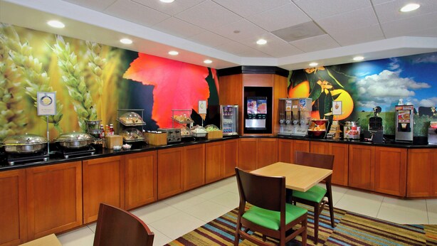 A breakfast bar with a variety of food options, a clock, and a mural on the wall.