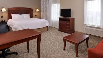 Una habitación de hotel con cama, televisión, escritorio, silla y cómoda.