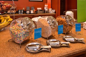 A breakfast buffet with various food items and utensils.