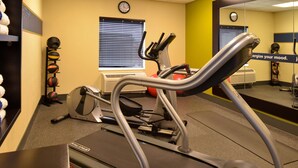 A gym with exercise equipment, including a treadmill and weights.