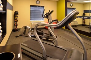 A gym with exercise equipment including a treadmill, stationary bike, and weights.