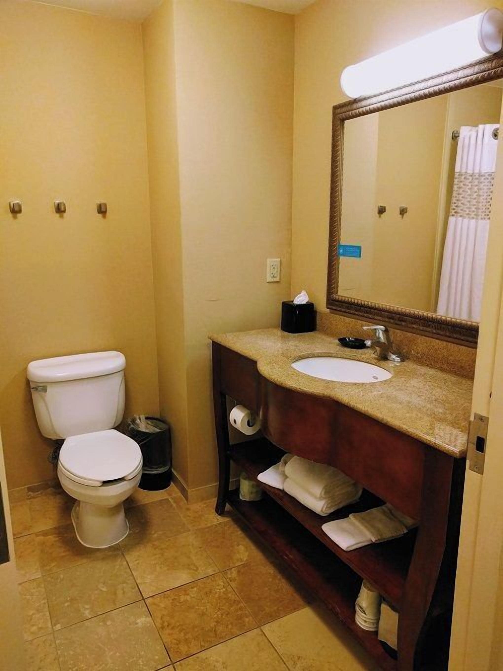 Ein kleines Badezimmer mit Toilette, Waschbecken und Spiegel.