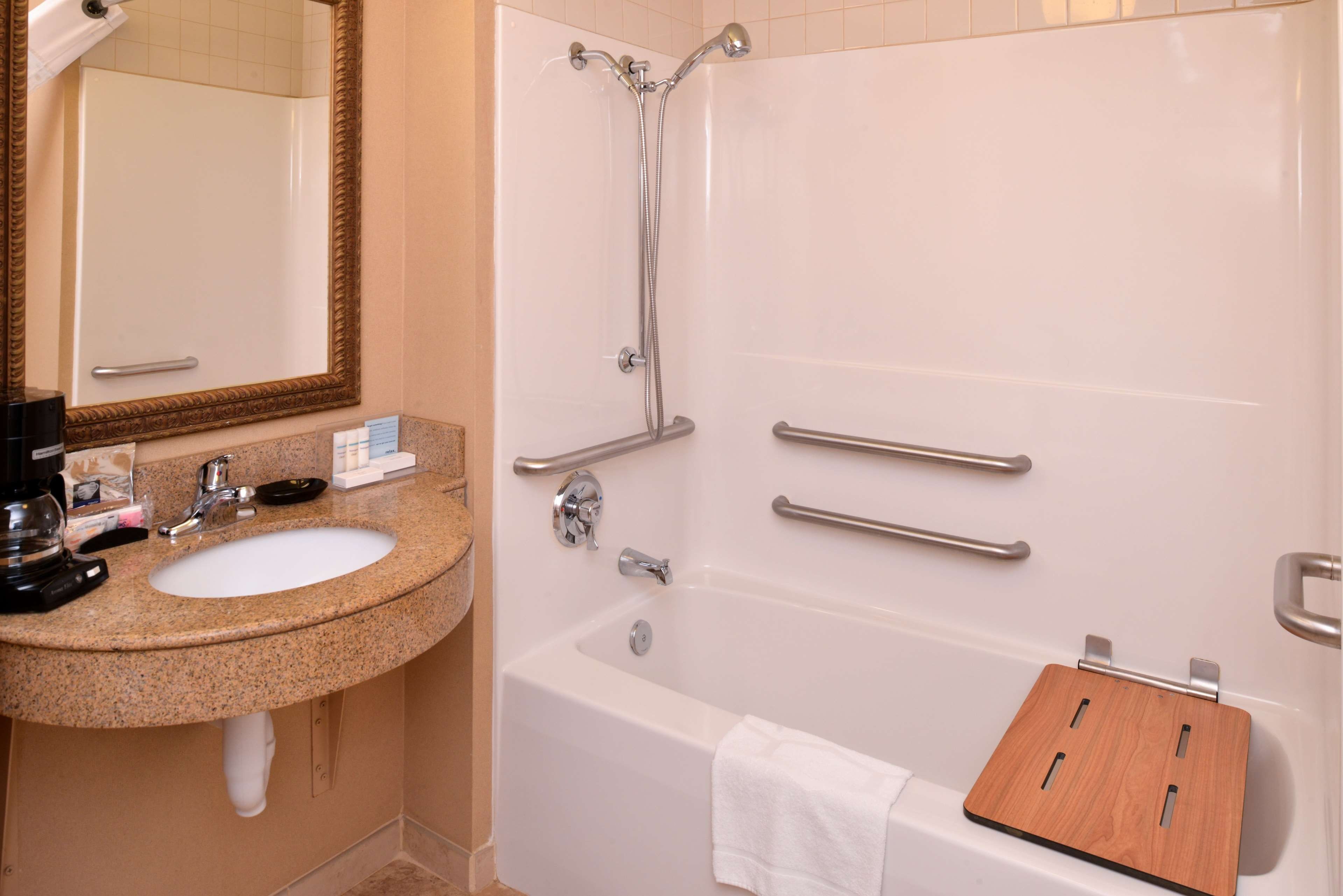 Un baño con lavamanos, espejo, ducha y bañera.