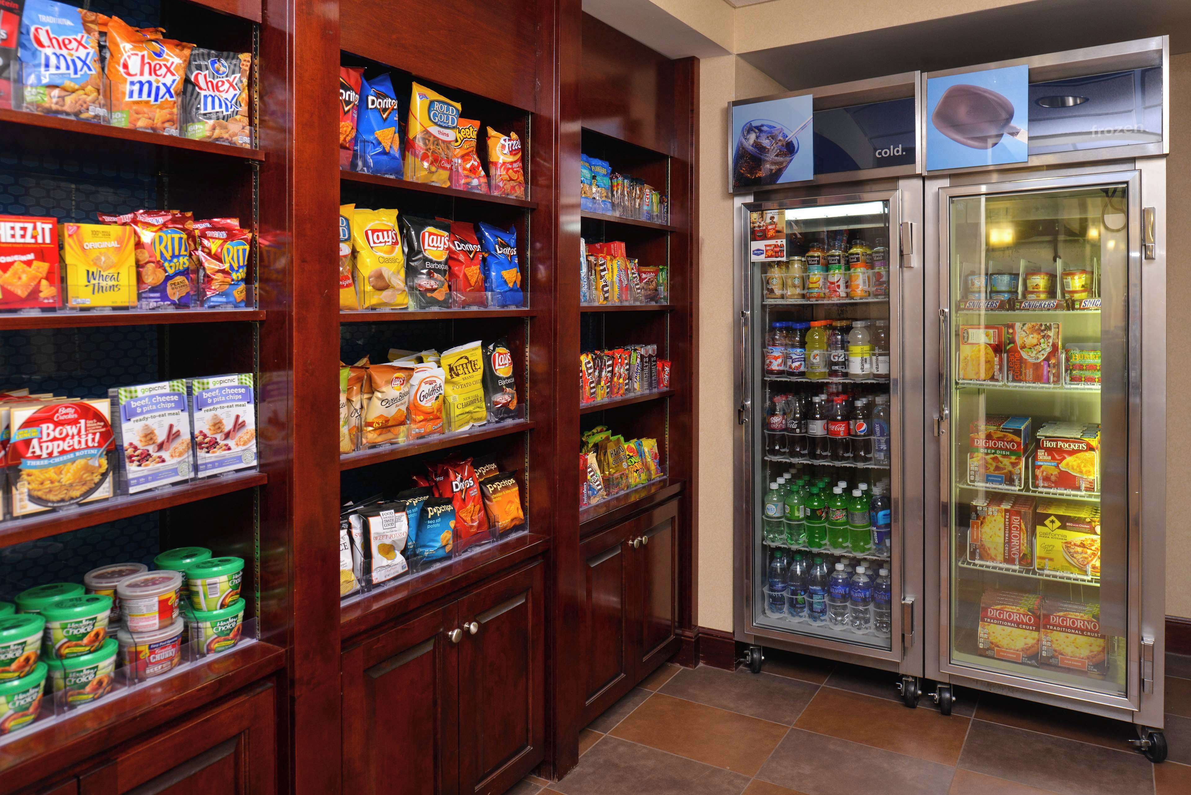 A snack and beverage section with shelves stocked with various snacks and a refrigerated display case.