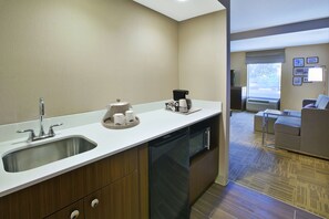 Una cocina moderna con un lavaplatos, lavamanos y cafetera.