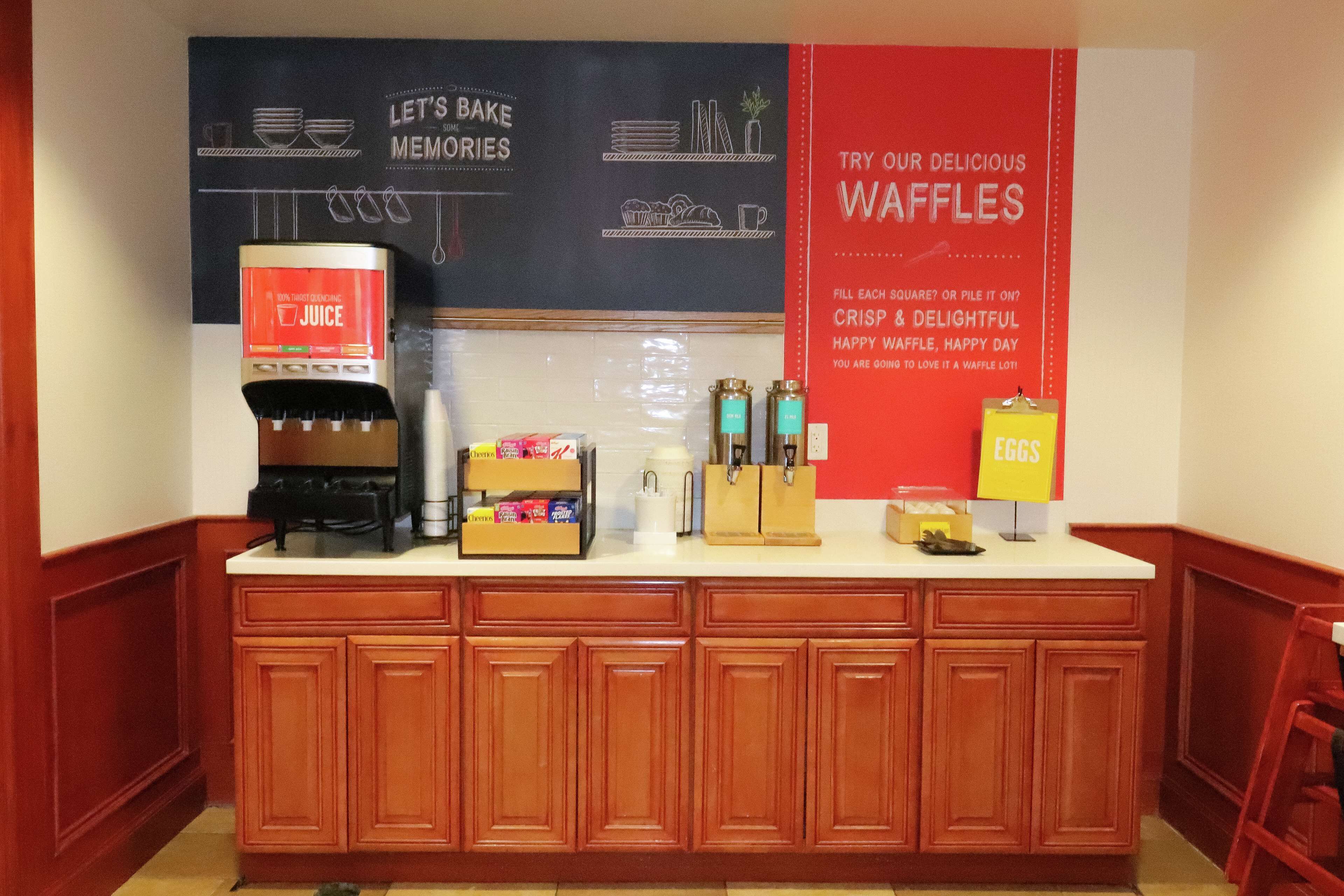 A kitchen counter with a coffee machine, waffle maker, and waffle station.