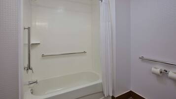 A bathroom with a white bathtub, a shower, and a toilet.