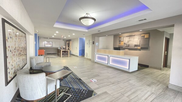 A spacious living area with a modern kitchen, a dining area, and a reception desk. - Holiday Inn Express Hotel & Suites Decatur by IHG (Decatur)