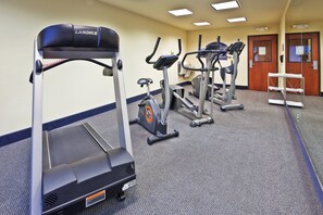 A fitness center with treadmills, ellipticals, and a bench. - Holiday Inn Express Hotel & Suites Paragould by IHG (Paragould)
