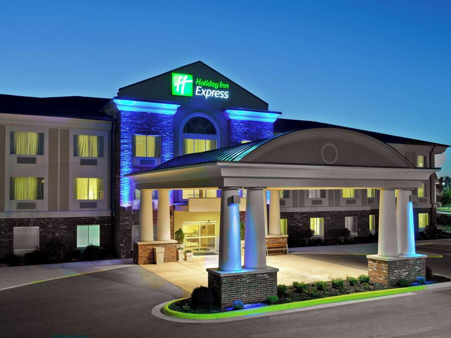 Un hôtel Holiday Inn Express doté d’une entrée couverte, d’une façade en briques et d’une enseigne lumineuse.