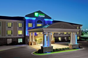 A Holiday Inn Express hotel with a covered entrance, brick facade, and illuminated signage.