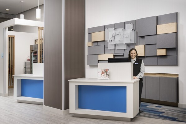 A hotel reception desk with a modern design, a digital display, and a blue accent. - Holiday Inn Express Knoxville-Strawberry Plains by IHG (Knoxville)