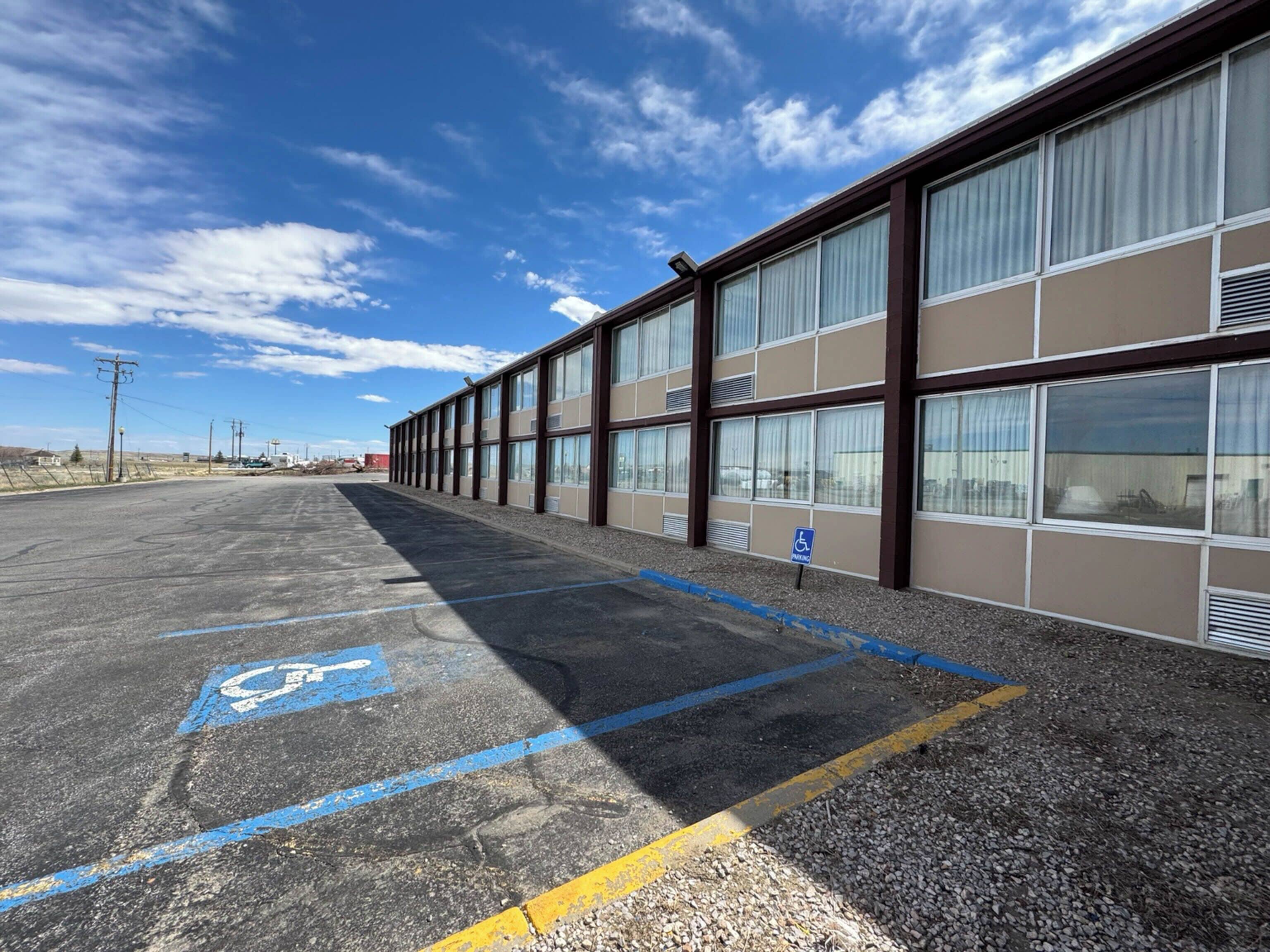 A parking lot with a handicap parking space marked by blue paint and a wheelchair symbol.