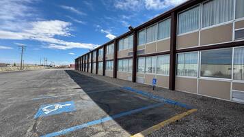 A parking lot with a handicap parking space marked by blue paint and a wheelchair symbol.