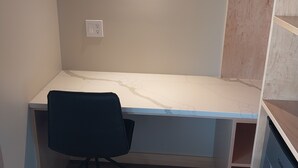 Une chambre à coucher de taille modeste, comprenant un lit simple, une table de chevet et une petite commode.