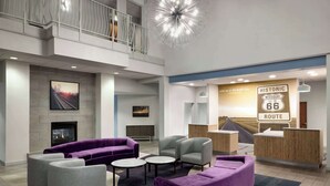 Un hall d’entrée moderne doté d’une cheminée, d’un espace salon et d’un comptoir d’accueil agrémenté d’une enseigne indiquant « Route historique 66 ».