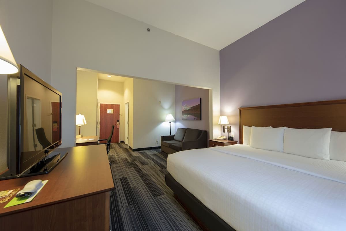 Ein Hotelzimmer mit Bett, Schreibtisch, Stuhl und Fernseher.