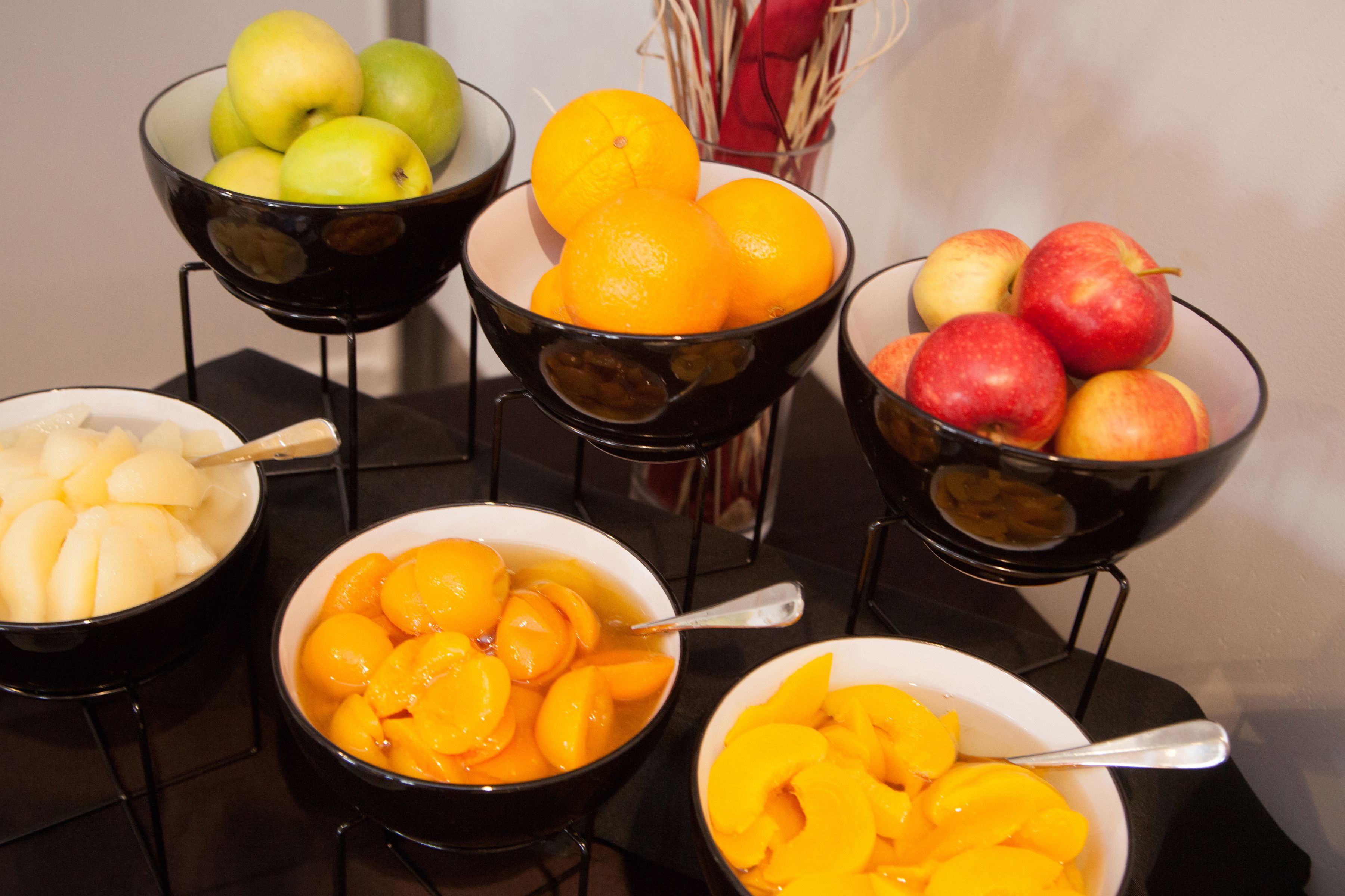 A table with bowls containing various fruits.