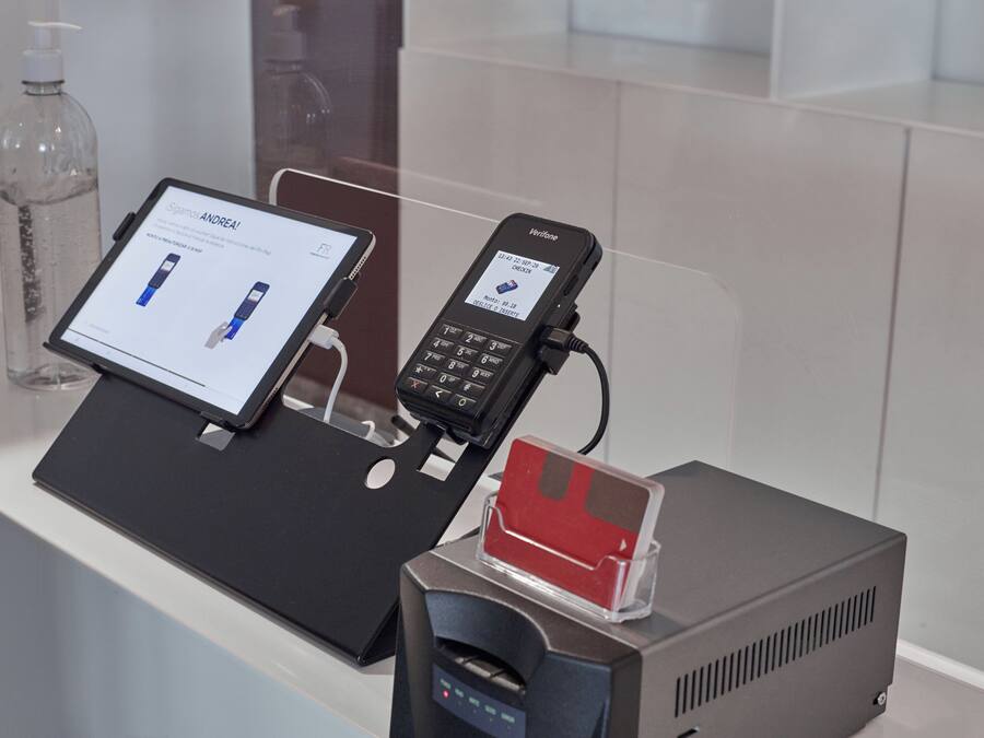 A modern bathroom with a digital kiosk, a mobile phone charging station, and a water dispenser.