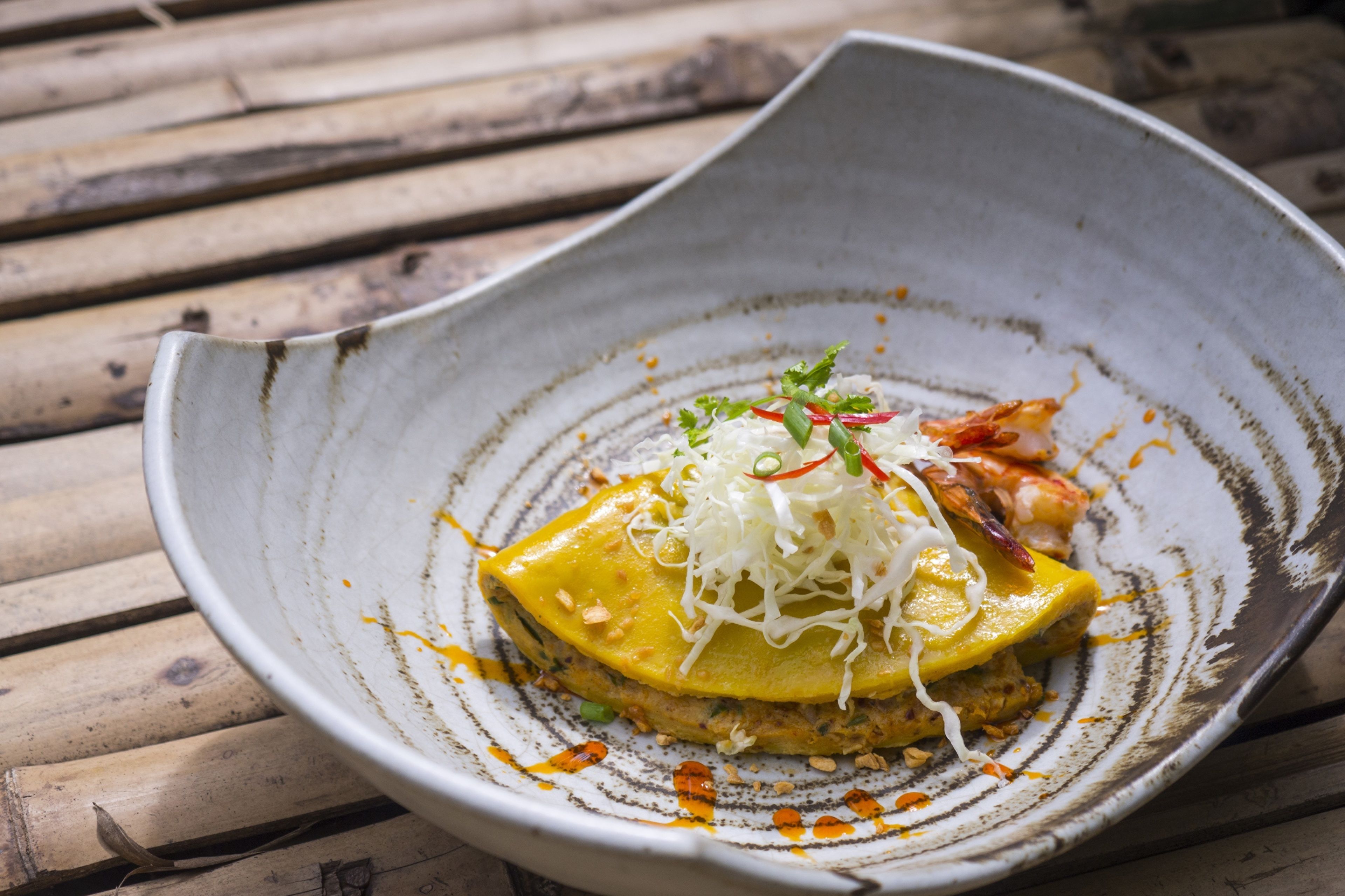 A bowl of food with a unique design, placed on a wooden surface.