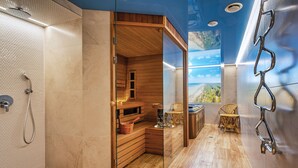 A modern bathroom with a wooden sauna, a glass-enclosed shower, and a view of the outdoors.