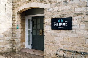 A stone building with a sign that reads "INN-INSPIRED FITNESS" and a door. - Holiday Inn Doncaster A1 M Jct 36 by IHG (Doncaster)