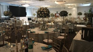 A banquet hall with round tables, chairs, and floral centerpieces. - Holiday Inn Doncaster A1 M Jct 36 by IHG (Doncaster)