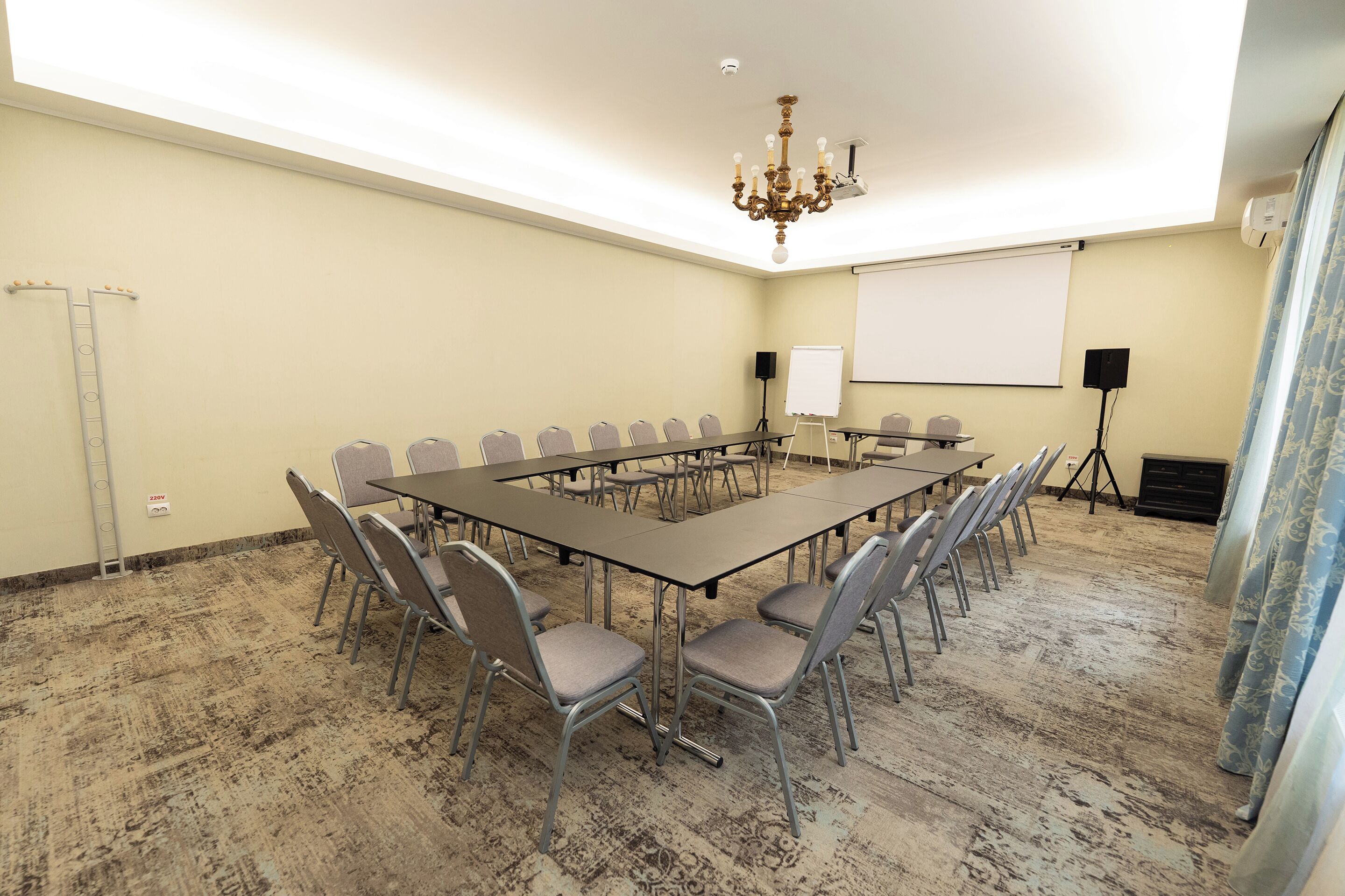 A conference room with a long table, chairs, a projector screen, and a whiteboard.