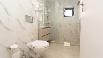 Standaard suite | Badkamer | Een bad/douchecombinatie, een regendouche, gratis toiletartikelen